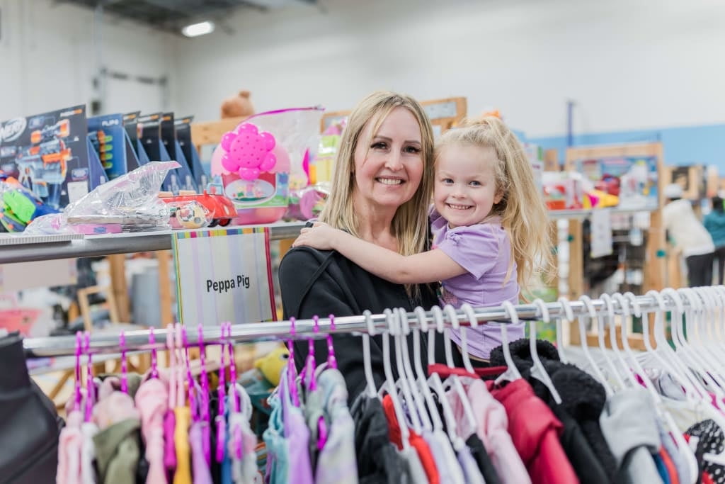 A cashier smiles behind her mask as she gets ready to check out the next happy JBF customer.